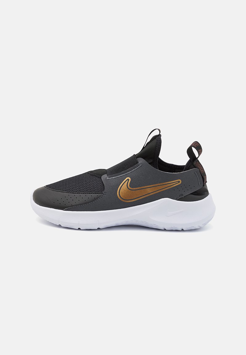 Sorte og grå sporty slip-on sko med en gullfarget Nike-logo, med en glatt overdel, teksturerte mesh-paneler og såle i hvit.