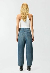 Jeans de tiro alto en denim de color azul claro, de pierna ancha, con dos bolsillos traseros y un acabado ligeramente desvaído.