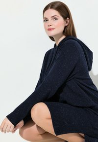 Námořnický svetr s kapucí, strukturovaným pletením, dlouhými rukávy a žebrovanými manžetami, s jemnými stříbrnými tečkami po celé tkanině.