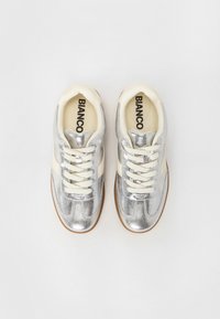 Sneakers metallici argento con accenti crema, punte rotonde e lacci bianchi. Parte superiore testurizzata e soletti beige con il marchio "BIANCO".