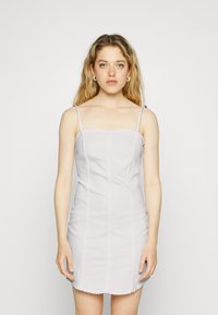 Vestido mini branco, justo, com alças finas, corpete estruturado e costuras verticais, feito de um tecido suave. Sem padrões ou detalhes notáveis.