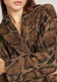 Bruine en zwarte dierenprint jas van een textuurstof, met een notch-kraag en drie-knopen manchetten.