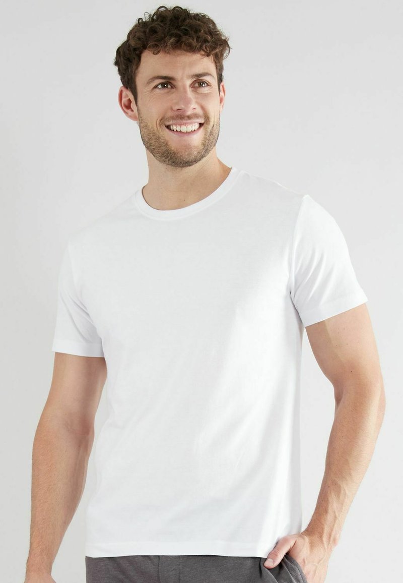 Weißes Baumwoll-T-Shirt mit rundem Halsausschnitt und kurzen Ärmeln, in regulärer Passform und glatter Textur. Minimalistisches Design ohne Muster.
