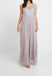 Langes Lavendelklei mit V-Ausschnitt, verziert mit silbernen Pailletten. Durchsichtige Überlagerung sorgt für Textur, mit einer fließenden Silhouette und einem dezenten Glanz.