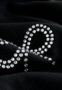 Tessuto nero con un design di strass scintillanti a motivo ad anelli, con una texture liscia e dettagli lucenti e riflettenti.