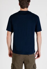 Maglietta a maniche corte blu navy con collo a giro, realizzata in materiale morbido. Design semplice, senza motivi o accenti visibili.