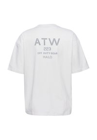 Weißes T-Shirt mit kurzen Ärmeln und grauem Text auf dem Rücken mit der Aufschrift „ATW 223 OFF DUTY GEAR HALO“ vor einfachem Hintergrund.