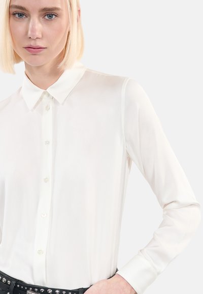 Witte lange mouwen shirt met een klassieke kraag, knopenlijst en gladde, lichte stof. Heeft een aansluitende pasvorm en manchet mouwen.