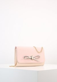 Rosa och beige läderhandväska med en guldkedjesnodd, en bågformad detalj och en stilren rektangulär design. Slät textur och minimalistisk stil.