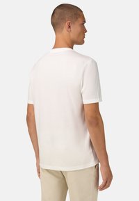 Biela bavlnená tričko s krátkymi rukávmi, okrúhlym výstrihom a hladkou textúrou. Pohľad zozadu, s voľným strihom a bez viditeľných log.