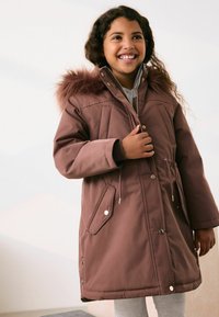 Brun, isoleret parka med hætte med pelskant, lynlås og trykknaplukning, elastisk talje og sidelommer. Glat yderstof med mat finish.
