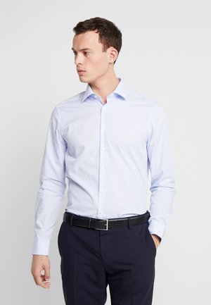 Hellblaues Hemd mit langen Ärmeln, das ein dezentes Streifenmuster und einen klassischen Kragen aufweist, kombiniert mit dunklen Hosen und einem schwarzen Gürtel.
