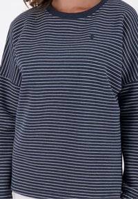Felpa a maniche lunghe a righe blu navy, con strisce orizzontali bianche e scollatura rotonda. Include un piccolo dettaglio del logo nero.
