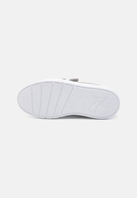 Semelle de sneaker blanche avec un motif de grip texturé, dotée d'un dessus en suède gris et d'un logo de marque prominent embossé sur la semelle.