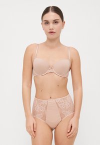 Beige gewatteerde bh met verstelbare bandjes en kantdetails. Bijpassende hoge taille slip met kantaccenten aan de zijkanten. Gladde stofafwerking.