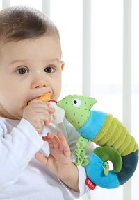 Jouet en peluche coloré de caméléon en vert et bleu, avec une queue texturée, des pois, et un corps ajustable, tenu par un enfant.