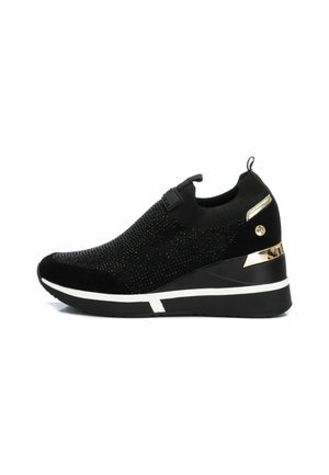Scarpa sportiva nera con tomaia in maglia tessurizzata, tacco a cuneo e accenti dorati sul tallone. Suola in gomma con dettaglio a striscia bianca.