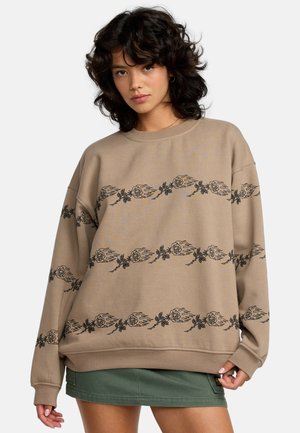 Bruine oversized sweatshirt van zacht materiaal, met een zwart bloemenpatroon en vlamaccenten over de borst en mouwen.