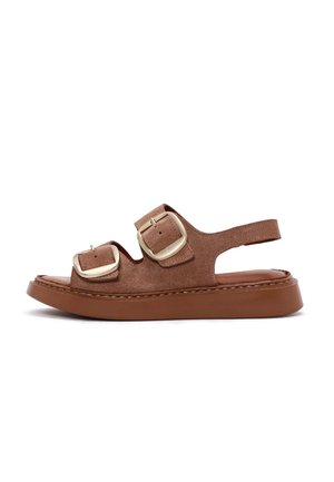 Brun ruskind sandal med åben tå, to store gyldne spænder og en rem omkring hælen, med en tyk brun sål.