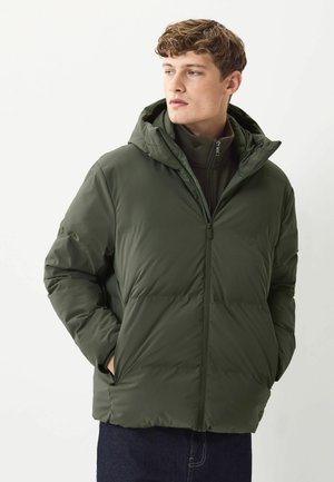 Olive green puffer jacket with a detachable hood, zip closure, and elastic cuffs. Features a padded texture and side pockets.