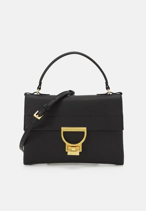 Black leather handbag with a structured shape, featuring a top handle, detachable strap, and a gold-tone clasp detail. Textured finish.