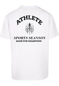 Hvid bomulds t-shirt med sort trykt tekst: "ATHLETE" over et emblem og "SPORTS SEASON MADE FOR CHAMPIONS" nedenunder. Klassisk crew neck design.