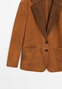 Brun mockaskinnsblazer med en slät yta, notch-lapeller, två framfickor och enknappsstängning. Minimalistisk design, utan foder.