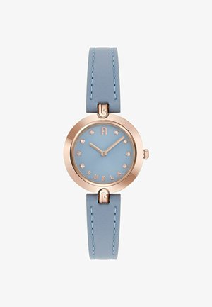 Round watch with a light blue leather strap and golden accents. The face features a matte blue dial and crystal hour markers with "FURLA" displayed.