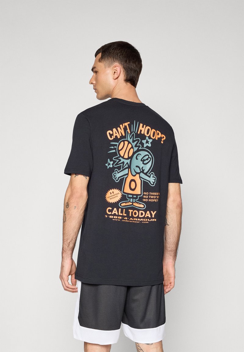 T-shirt noir en coton avec un graphique coloré de dessin animé au dos, avec le texte "TU NE SAIS PAS JOUER ?" et un motif de basketball. Manches courtes.