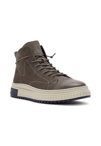 Bruine leren hoge sneakers met een beige en marineblauwe zool, voorzien van een vetersluiting, stikseldetails en een logo aan de zijkant.