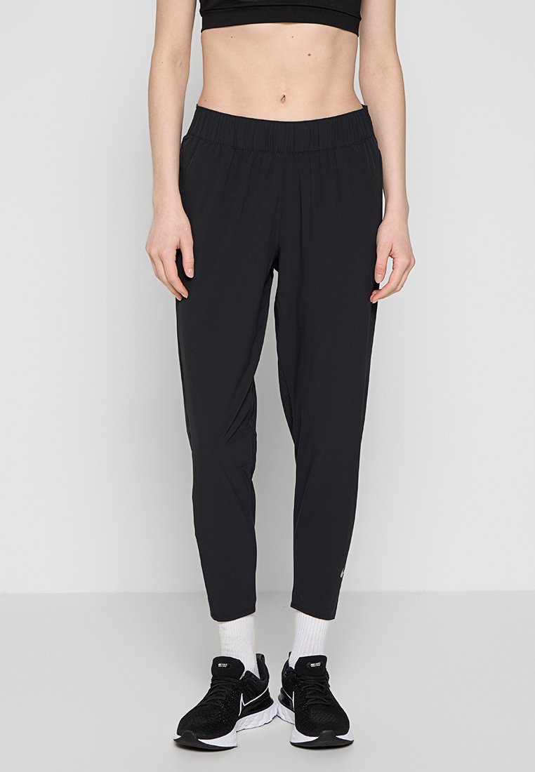 Pantalons de sport noirs en matériau léger, dotés d'une taille élastique, de jambes fuselées et d'un accent logo discret au niveau de la cheville.