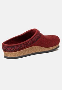 Rød uld filt slip-on træskor med et dekorativt sort mønstret bånd og en kork midthus, der har en tekstureret gummisål.