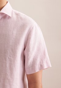 Lichtroze kortmouwshirt van linnen met een kraag, met een gestructureerde, licht gekreukte uitstraling en subtiele stiksels.