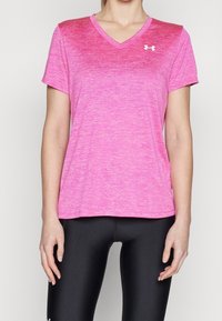 Rosa atletisk v-ringad t-shirt med korta ärmar, med en melerad textur och en liten vit logotyp på bröstet. Tänkt att bäras tillsammans med svarta leggings.