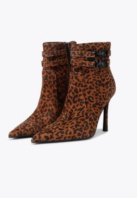 Leopard print ankle boots made of suede with pointed toes, zip closure, and two decorative straps featuring circular hardware accents.