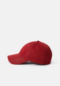 Rød baseball cap lavet af stof, med en buet skygge, seks-panel design, syede detaljer og synlige lufthuller til ventilation.