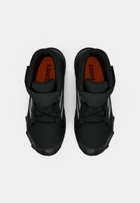 Pantofi sport negri cu guler căptușit, material din plasă și talpă din cauciuc. Prezentând accente reflective și un sistem de șireturi pentru o fixare sigură.