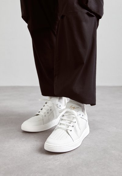 Hvide højtop sneakers lavet af glat læder har perforerede tådetaljer, flade hvide snørebånd og en diskret guldaccent på hælen.