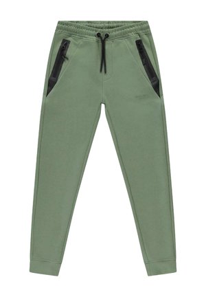 Groene joggingbroek van zacht materiaal, met twee zwarte ritszakken en een elastische tailleband met trekkoord.