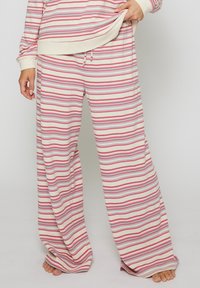 Randig lounge-set som inkluderar vida byxor i krämfärg med rosa och ljusblå horisontella ränder, mjukt material och justerbart snöre i midjan.