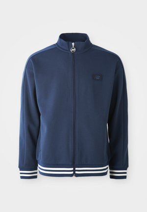 Navy track jacket with high collar, full zipper, and front logo. Features white stripe accents on cuffs and hem, made from smooth fabric.