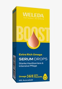 Confezione di Weleda Boost Extra Rich Omega Serum Drops in giallo e blu, che evidenzia la forte barriera cutanea, la cura intensa e gli ingredienti a base di olio di avocado.