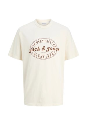 Kreemi värvi puuvillane T-särk, millel on pruuni värvi graafika, kus on tekst "Jack & Jones" ja "Since 1990" ovaalses disainis. Lühikesed varrukad.