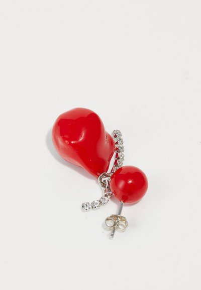 Orecchino in plastica rossa con un charm a forma di cuore e una perla rotonda, collegati da una catena argentata con accenti di cristallo.
