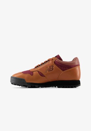Brown leather and burgundy textile sneaker, featuring a black rubber sole, textured accents, rounded toe, and prominent logo on the side.