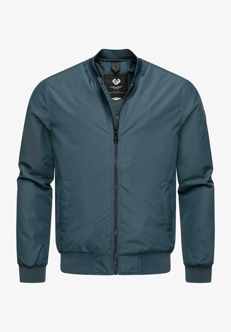 Gadala jaka tumši tīkkle, izgatavota no gludas auduma. Iekļauj rāvējslēdzēja aizdari, stāvus apkakli, un ribinātas piedurknes ar sānu kabatām.