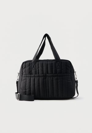 Sac cabas en tissu matelassé noir avec deux poignées de transport et une bandoulière réglable sur fond blanc uni.