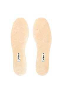 Plantillas Hunter, color beige claro, de textura suave, diseñadas para adaptarse a los pies, con logo impreso en negro en un lado, pensadas para proporcionar comodidad y calidez.