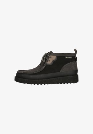 Bottes imperméables noires et grises avec un dessus texturé, fermeture lacée et épaisse semelle en caoutchouc mouchetée. Présente le logo Gore-Tex.