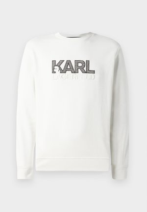 Hvit genser med rund hals som har hevet svart "KARL" logo og brodert "LAGERFELD" tekst. Myk stoff med ribbestrikkede mansjetter og kant.